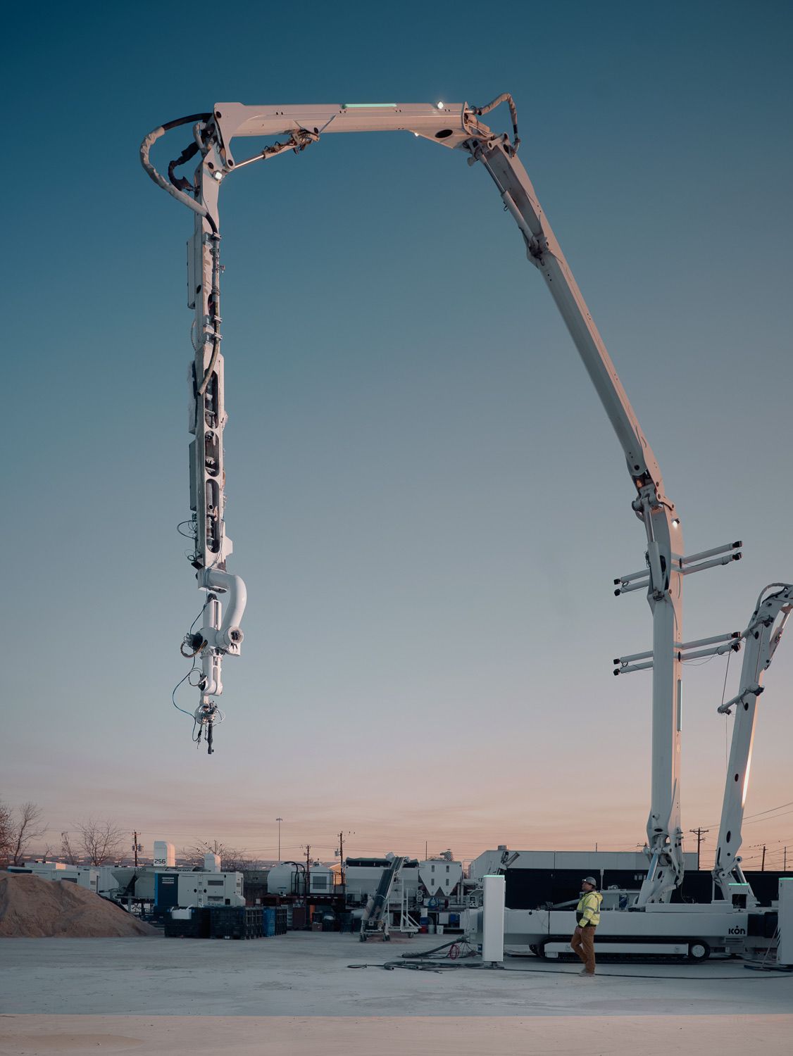 ICON Titan construction system at sunset, showing its full robotic printer structure at a construction site.